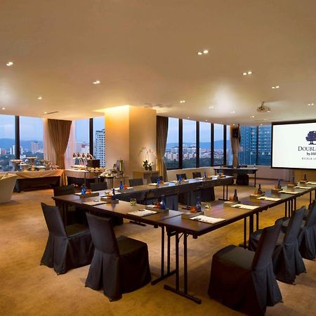Doubletree By Hilton Kuala Lumpur Hotel Екстериор снимка The photo shows a modern conference room. It features a long table arranged for a meeting, with black chairs and notepads placed at each seat. The room has large windows that let in natural light and offer a view of the city outside. On one wall, the